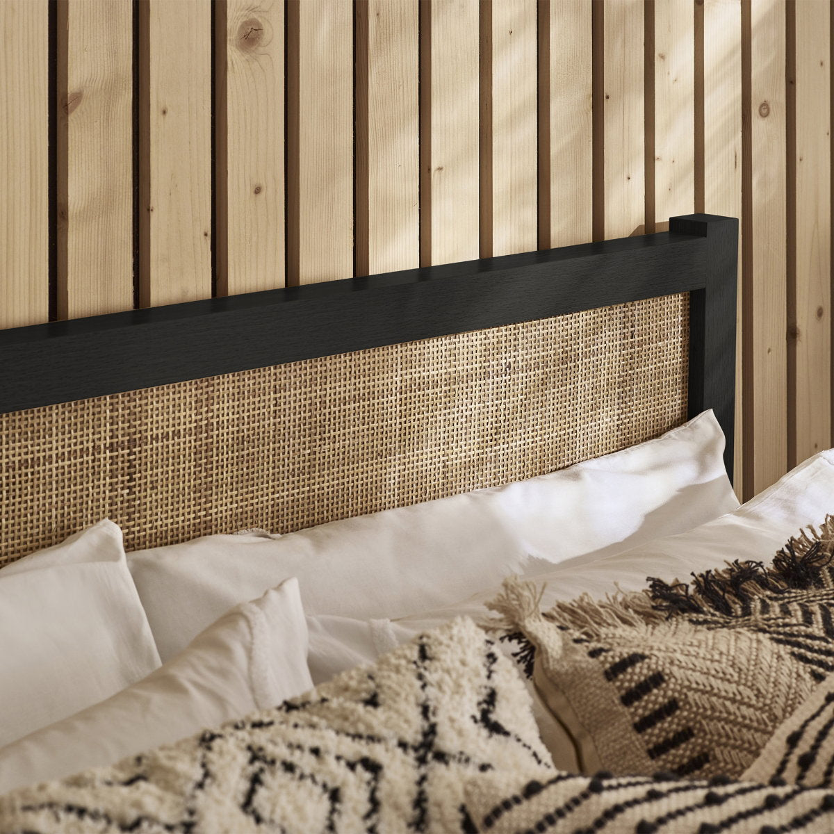 Close-up of the woven rattan cane headboard within the black oak frame