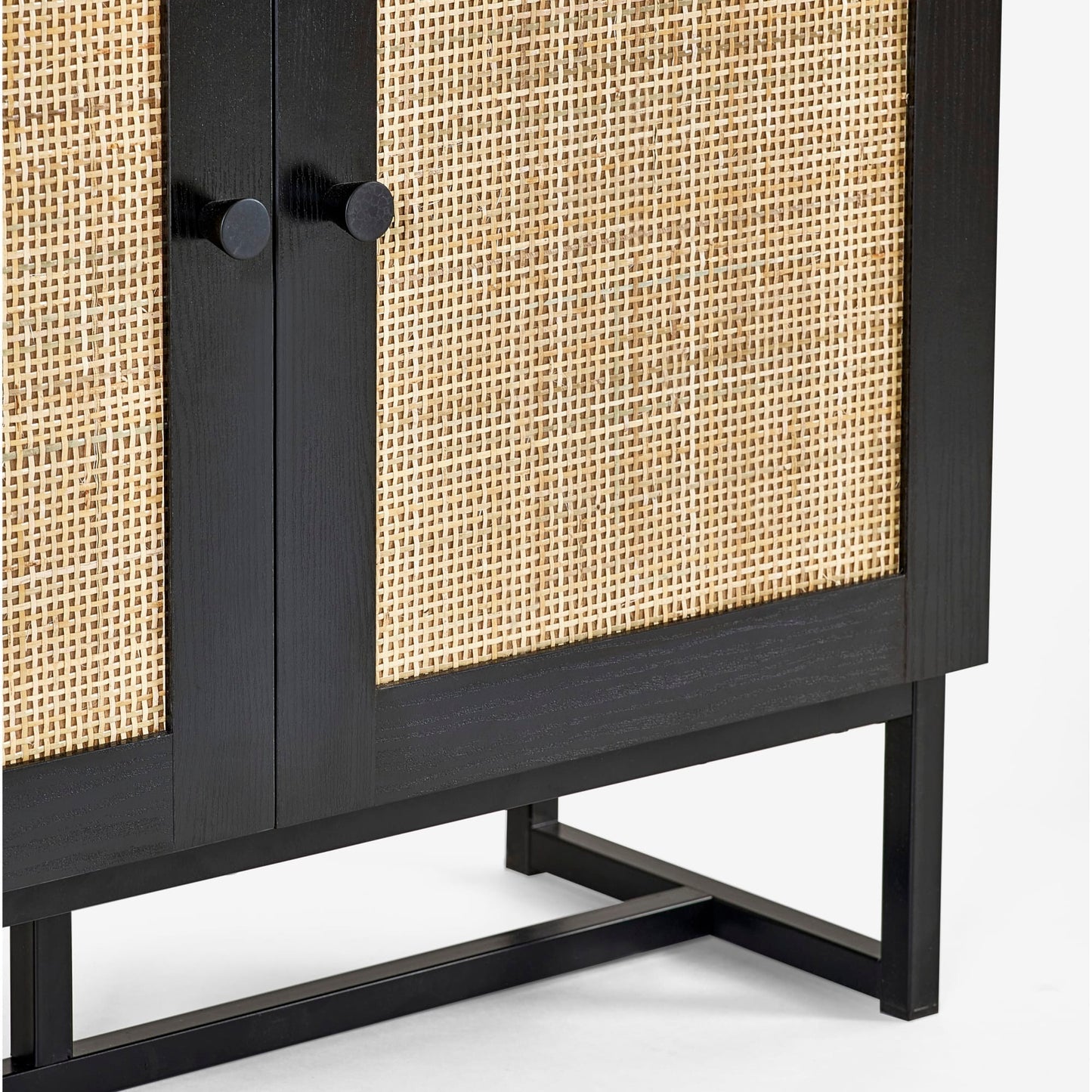 Close-up shot of the natural cane door weave and black metal handles on the black oak bookcase