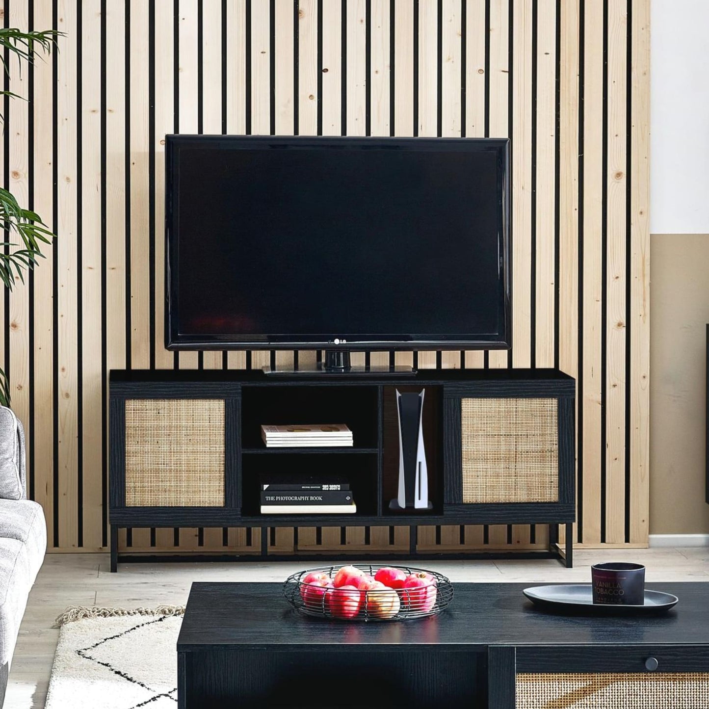 Padstow black oak rattan TV unit styled with flat-screen television in modern living room