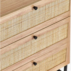 Close-up view of the natural cane rattan drawer fronts and black hardware on oak chest