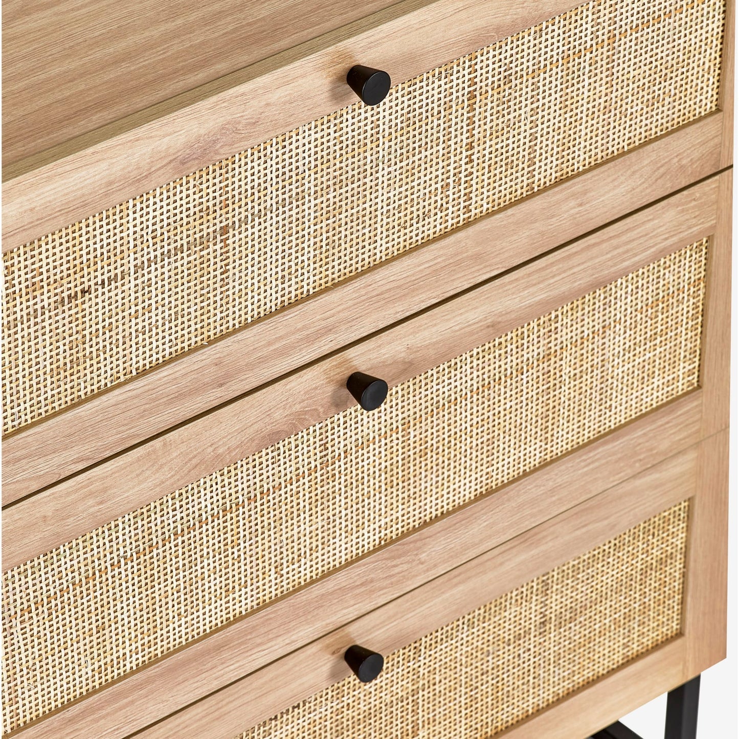 Close-up view of the natural cane rattan drawer fronts and black hardware on oak chest