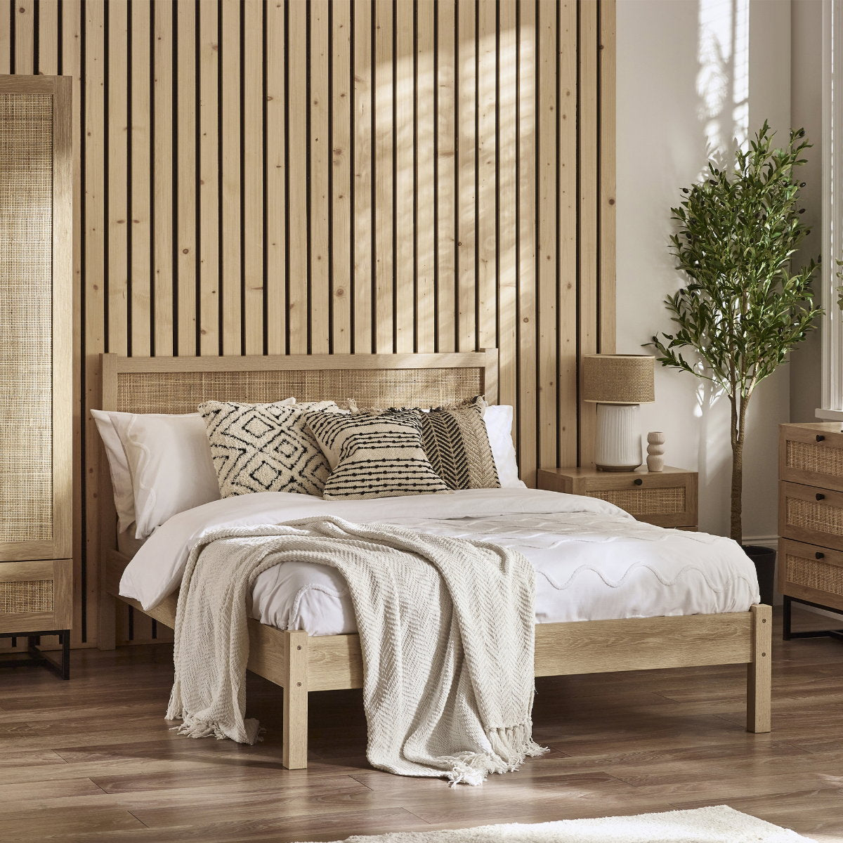 Padstow natural oak wood bed frame with cane headboard in a styled bedroom