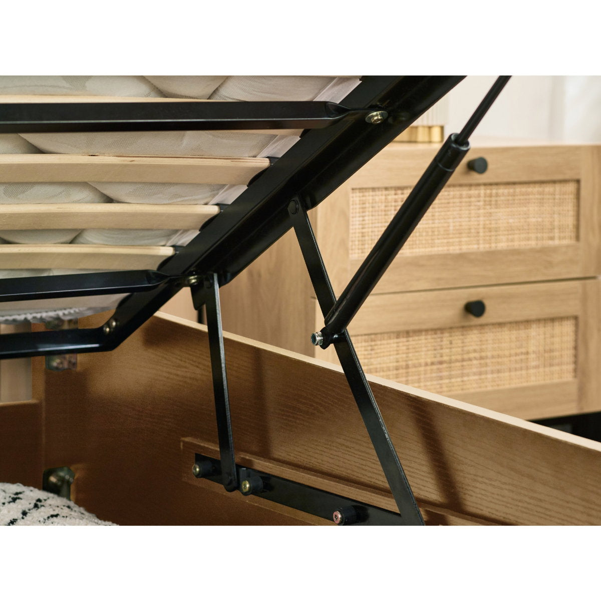 Close-up view of the internal hydraulic gas lift mechanism on the ottoman bed