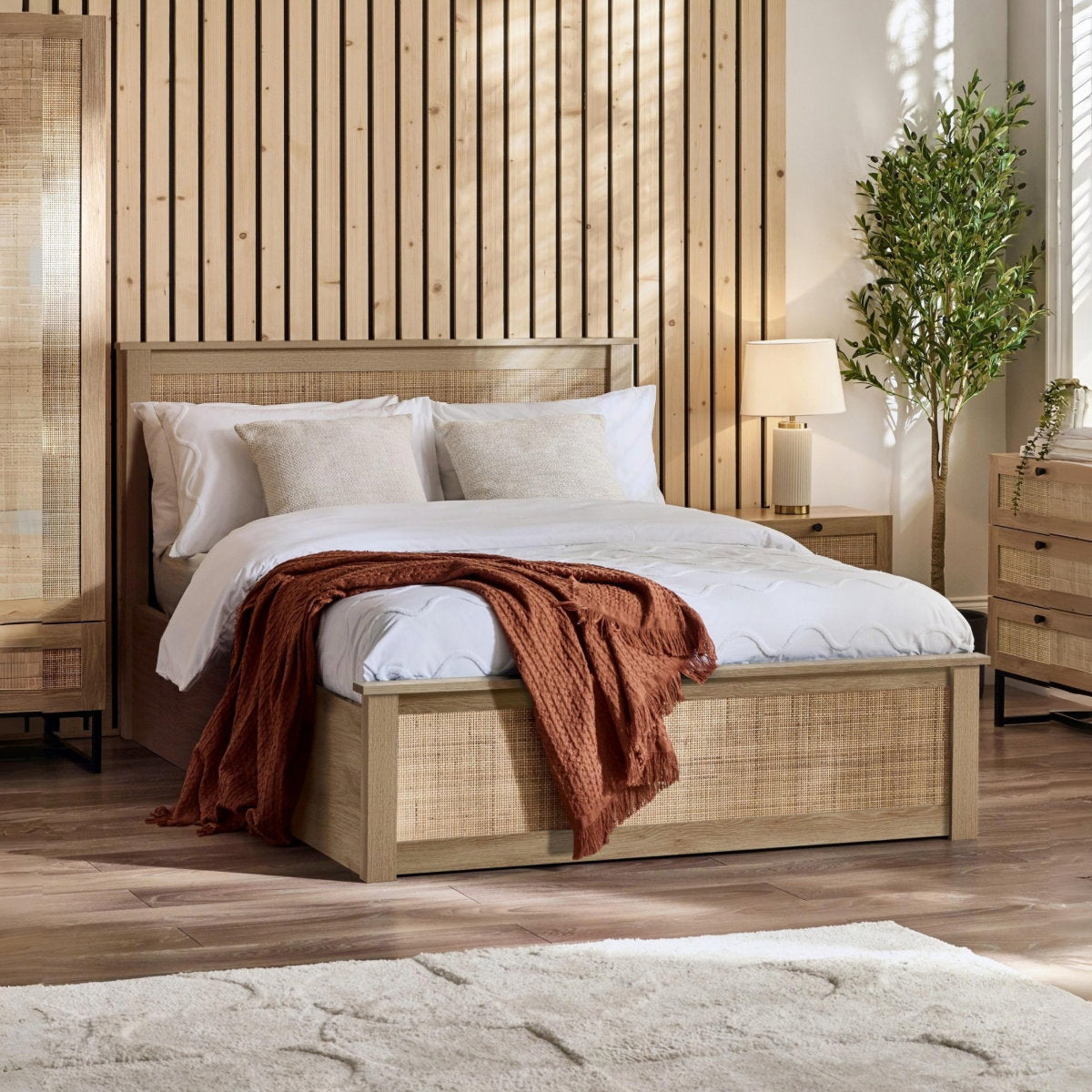 Padstow natural oak ottoman bed with lift-up storage styled in a bedroom