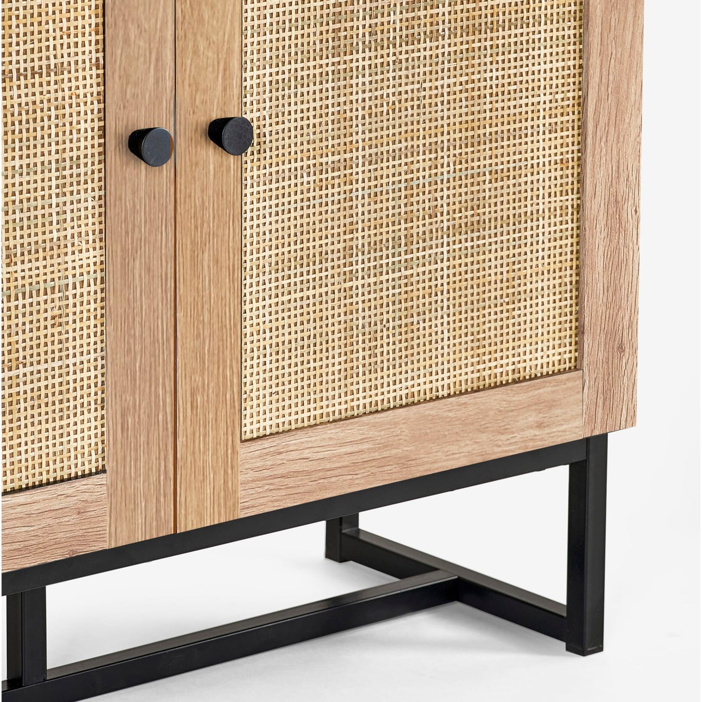 Close-up view of the woven natural cane door panel and black metal base on the oak bookcase