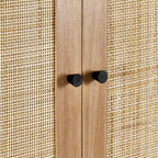 Close-up shot of the woven natural cane door panel and round black handles on the oak wardrobe