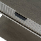 Close-up view of the black metal lip handle and vertical fluted wood pattern on the top drawer of the side table