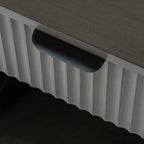 Close-up shot showing the black metal lip handle and vertical fluted wood detail on the top drawer