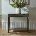 Reed fluted 2 drawer console table styled in a hallway with a floral vase on top and candles on the open lower shelf
