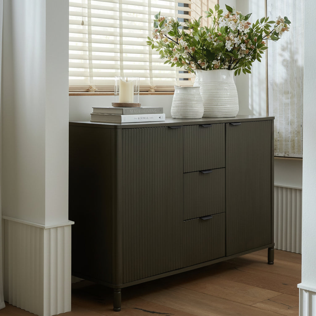 Reed fluted 3 drawer 2 door sideboard cabinet styled in a bright dining room setting with decorative vase and artwork