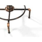 Close-up shot of the copper-rubbed metal pipe joints and integrated circular footrest base on the Rockport bar table