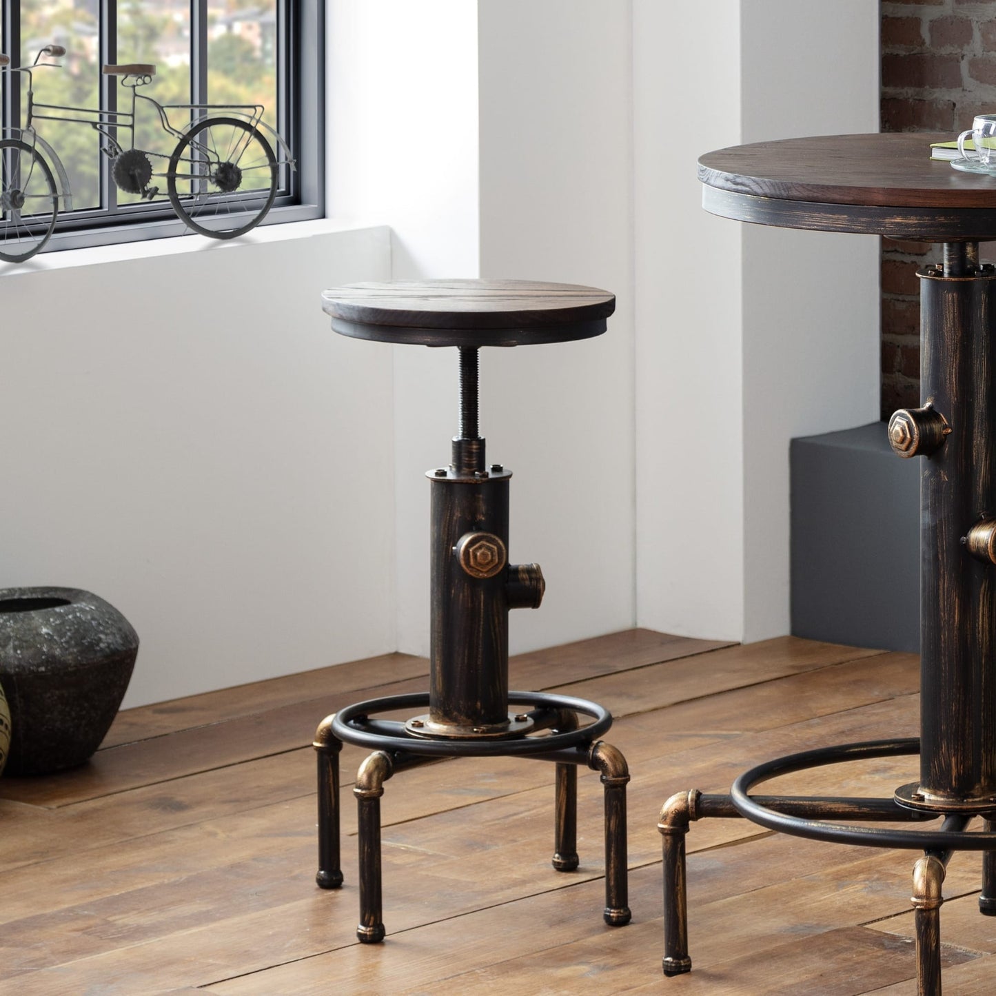 Rockport industrial pipework barstool styled next to the matching high bar table in an industrial loft setting