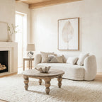Sorelle boucle 2 seater sofa with cushions styled in a contemporary living room around a rustic wooden round coffee table and plush rug