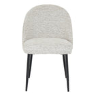 Front view showing the rounded backrest and black metal tapered legs of the Sorelle boucle dining chair