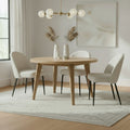 Sorelle boucle dining chairs with black legs arranged around a round wooden dining table on a neutral rug