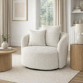 Sorelle boucle swivel accent chair styled in a neutral modern lounge with a floor lamp and decorative side table