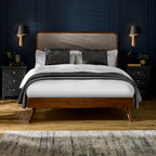 Walden solid hardwood double bed frame with chenille headboard styled with dark blue wood panelling, bedside tables, and lamps