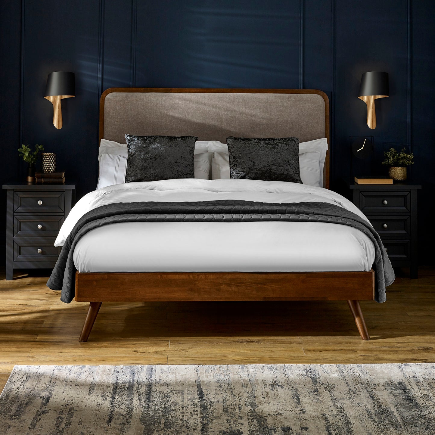 Walden solid hardwood double bed frame with chenille headboard styled with dark blue wood panelling, bedside tables, and lamps