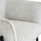 Close-up detail showing the soft woven fabric texture and curved armrest on the Zephra Armchair.