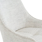 Close-up detail of the woven neutral fabric texture and swooped armrest on the Zephra Chair.